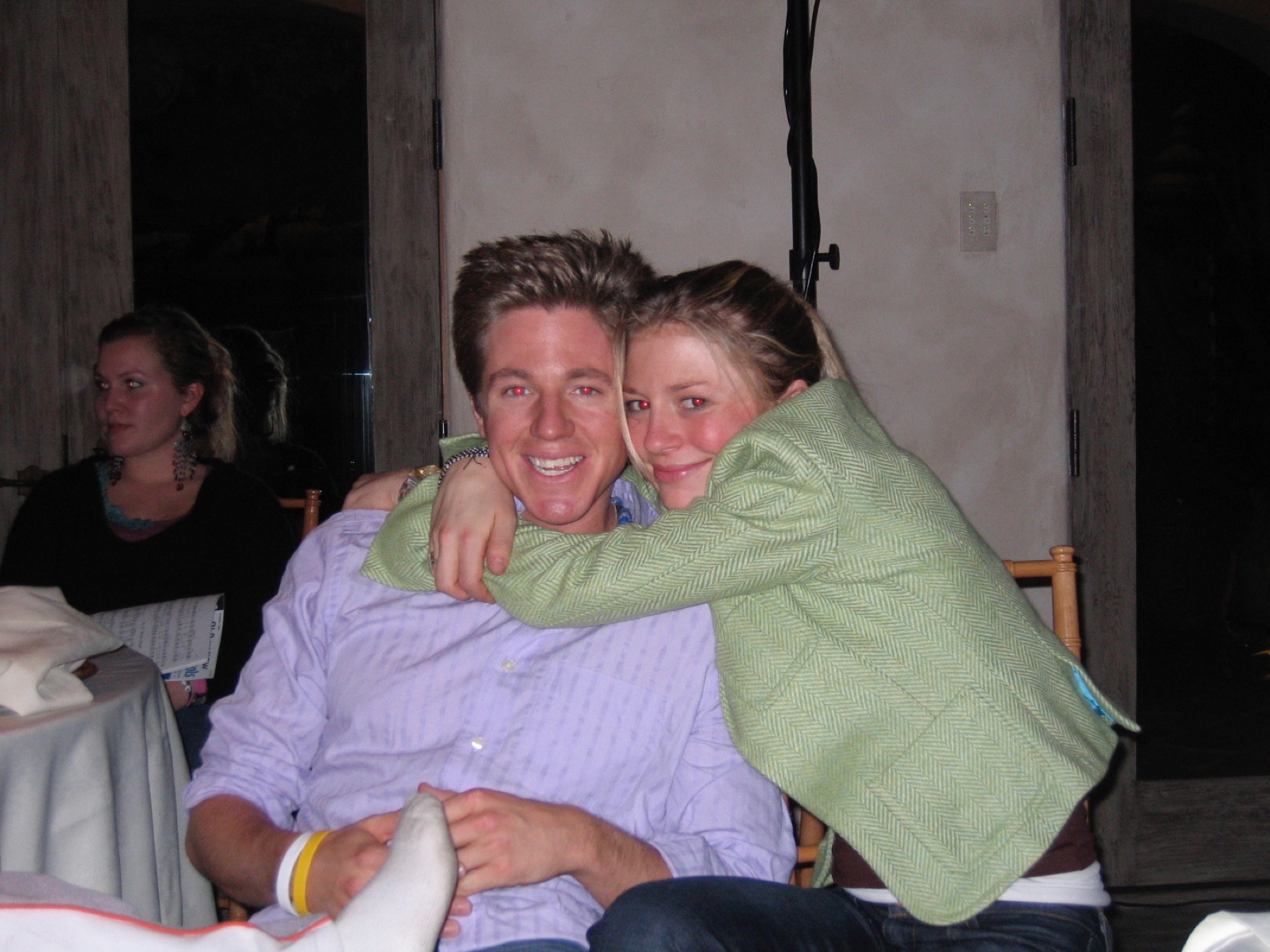 Brian smiling while being hugged at a gathering